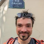 Portrait of Konrad Völkel in front of the Rue Cauchy street sign in Paris
